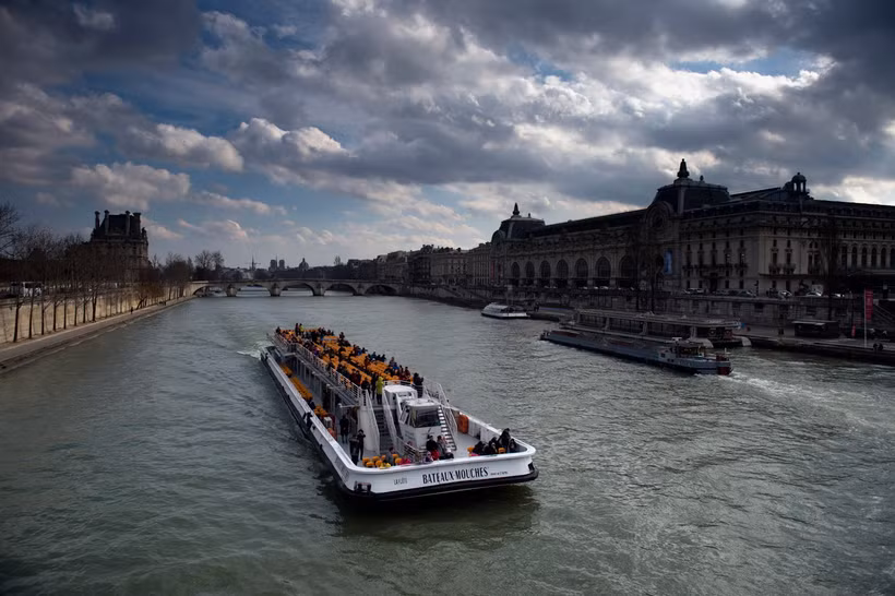 Các thuyền chở khách du lịch di chuyển trên sông Seine ở Paris, Pháp. (Ảnh: AFP/TTXVN)