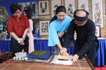 Du khách trải nghiệm in tranh dân gian Đông Hồ. (Ảnh: Thanh Thương/TTXVN)