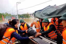 Đại tá Nguyễn Văn Hòa, Phó Tham mưu trưởng Quân khu 5, trực tiếp trao nhu yếu phẩm thiết yếu cho người dân vùng ngập lũ. (Ảnh: Đoàn Hữu Trung/TTXVN)
