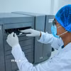 Kỹ thuật viên thực hiện xét nghiệm ADN thân nhân liệt sỹ trên máy microarray GeneTitan thể mô có thể phân tích hàng nghìn mẫu mô cùng lúc để tìm đột biến di truyền hoặc mức độ hoạt động của gene. (Ảnh: Hoàng Hiếu/TTXVN)