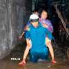 Hỗ trợ người già di chuyển khỏi khu vực ngập sâu đến nơi an toàn. (Ảnh: Nguyễn Thanh/TTXVN)