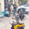 Lực lượng chức năng đang khám nghiệm xe môtô trong vụ tai nạn. (Ảnh: Mạnh Tú/TTXVN