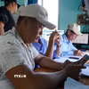 Ngư dân thực hiện khai báo điện tử trước khi vươn khơi. (Ảnh: Đình Quân/TTXVN)