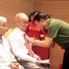 Đại tướng Lương Tam Quang, Ủy viên Bộ Chính trị, Bộ trưởng Bộ Công an trao tặng Huy hiệu 80 năm tuổi Đảng cho các đảng viên. (Ảnh: Đinh Văn Nhiều/TTXVN)