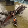 Sà lan bị chìm tại chân cầu Mỹ Chánh được lực lượng cứu hộ dùng cần cẩu kéo nổi, trục vớt an toàn. (Ảnh: Nguyên Linh/TTXVN)
