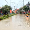 Người dân xã Thất Khê, tỉnh Lạng Sơn di chuyển bằng bè trên Quốc lộ 4A. (Ảnh: Văn Đạt/TTXVN)