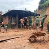 Cán bộ, chiến sĩ Lữ đoàn 574 (Bộ Tư lệnh Quân khu 5) hỗ trợ người dân xã Quế Phước (Đà Nẵng) khắc phục hậu quả của mưa lũ. (Ảnh: TTXVN phát)