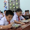 Học sinh vui vẻ với bữa ăn bán trú do Nhà trường tổ chức nấu. (Ảnh: Phan Sáu/TTXVN)