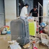 Người dân xã Ninh Phước (Khánh Hòa) dọn dẹp nhà cửa sau mưa lũ. (Ảnh: Nguyễn Thành/TTXVN)
