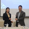 Chị Nguyễn Thị Bích Diệp của ASVI và Francesco Maringiò của Fondazione Italy-Vietnam ký thỏa thuận hợp tác. (Ảnh: Trường Dụy/TTXVN)