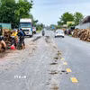Bùn đất rơi vãi trên lề và mặt đường trong quá trình bốc dỡ, vận chuyển gỗ, làm tăng nguy cơ mất an toàn giao thông trên Quốc lộ 22B. (Ảnh: Minh Phú/TTXVN)