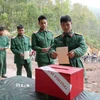 Các chiến sỹ Tiểu đoàn 1, Lữ đoàn 543, Quân khu 2 tiến hành bỏ phiếu vào thùng phiếu phụ của Tổ bầu cử số 1, xã Sín Thầu. (Ảnh: Trung Kiên/TTXVN)