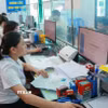 Cán bộ Trung tâm phục vụ hành chính công xã Nam Minh, tỉnh Ninh Bình làm thủ tục cho người dân. (Ảnh: Công Luật/TTXVN)
