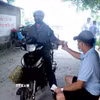 Người dân khi qua cầu Đún phải trả phí trực tiếp cho người gác barie bên xã Thần Khê, tỉnh Hưng Yên. (Ảnh: Đinh Văn Nhiều/TTXVN)