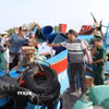 Lực lượng Bộ đội Biên phòng Đồng Tháp tặng quà, tuyên truyền cho ngư dân chấp hành quy định khai báo trước khi ra khơi. (Ảnh: Hữu Chí/TTXVN)