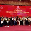 Đại diện Ban chấp hành Hội Nhà văn Việt Nam trao quyết định kết nạp hội viên mới. (Ảnh: Phương Lan/TTXVN)