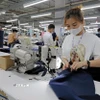 Sản xuất quần áo xuất khẩu sang thị trường Hoa Kỳ tại Công ty may TAL Vĩnh Phúc. (Ảnh: Trần Việt/TTXVN) 