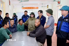 Lãnh đạo xã Bắc Trạch, tỉnh Quảng Trị hỏi thăm, động viên 4 ngư dân may mắn thoát nạn trong vụ chìm tàu do bão số 10 trên sông Gianh. (Ảnh: Nguyên Linh/TTXVN)
