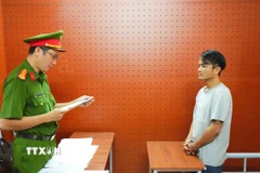 Công an phường Ninh Kiều tống đạt Quyết định khởi tố bị can của Cơ quan Cảnh sát Điều tra đối với Châu Hoàng Hương. (Ảnh: TTXVN phát)