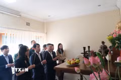 Dâng hương tại bàn thờ Bác đặt tại Trụ sở Đại sứ quán Việt Nam tại Nam Phi. (Ảnh: Hồng Minh/TTXVN)