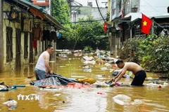 Người dân dọn dẹp nhà cửa sau trận lụt ở phường Hà Giang 1 (Tuyên Quang). (Ảnh: Đức Thọ/TTXVN)