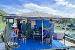 Lực lượng chức năng xã Cái Chiên, Quảng Ninh, tuyên truyền, nhắc nhở người dân trở về đất liền trước khi bão số 9 đổ bộ. (Ảnh: Thanh Trường/TTXVN phát)