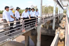 Phó Chủ tịch UBND tỉnh Vĩnh Long Châu Văn Hòa (thứ 4, từ trái qua) cùng sở, ngành khảo sát tại cống Vĩnh Kim (xã Vinh Kim). (Ảnh: Thanh Hòa/TTXVN)