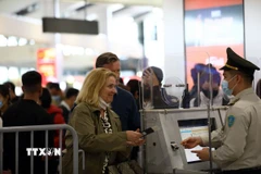Nhân viên an ninh hàng không kiểm tra thông tin hành khách trước khi vào điểm soi chiếu an ninh. (Ảnh: Huy Hùng/TTXVN)