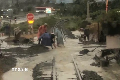 Đoạn đường sắt bị nước ngập, đất đá tràn vào đường ray, gây mất an toàn ở địa phận đường sắt chạy ngang xã Nam Cam Ranh, Khánh Hòa. (Ảnh: TTXVN phát)