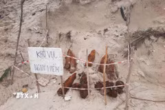 Đồn Biên phòng Triệu Vân (Bộ đội Biên phòng Quảng Trị) và các đơn vị chức năng khoanh vùng hiện trường, cắm biển cảnh báo nguy hiểm khu vực bom mìn sót lại sau chiến tranh. (Ảnh: TTXVN phát)