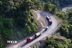 Đoàn xe nối thùng đổ đèo trên Quốc lộ 8A đoạn qua tỉnh Hà Tĩnh trước khi về Cảng Cửa Lò (Nghệ An). (Ảnh: Hữu Quyết/TTXVN)