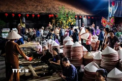 Phiên chợ nón làng Chuông họp theo các ngày 4, 10, 14, 20, 24 và 30 âm lịch hằng tháng, diễn ra từ khoảng 4 giờ 30-7 giờ sáng. (Ảnh: Vân Chi/TTXVN phát)