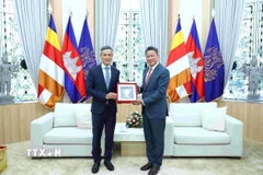 Đại sứ Việt Nam tại Campuchia Nguyễn Minh Vũ (bên trái) trao tặng phẩm lưu niệm cho Phó Thủ tướng kiêm Phó Chủ tịch thứ nhất CDC Sun Chanthol. (Ảnh: TTXVN phát)