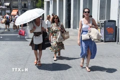Người dân di chuyển dưới trời nắng gay gắt tại Madrid, Tây Ban Nha. (Ảnh: THX/TTXVN)
