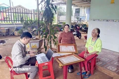 Hỗ trợ bà con đồng bào dân tộc thiểu số thực hiện các thủ tục hành chính ngay tại nhà. (Ảnh: Hưng Thịnh/Vietnam+)