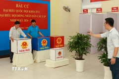 Các thành viên tổ bầu cử đang tiến hành việc thiết lập, bố trí khu vực bỏ phiếu ở phường Bàn Cờ, Thành phố Hồ Chí Minh. (Ảnh: Hữu Duyên/TTXVN)