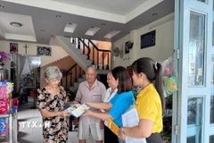 Cán bộ, nhân viên Bảo hiểm xã hội thành phố Cần Thơ tuyên truyền, vận động người dân tham gia bảo hiểm xã hội. (Ảnh: TTXVN phát)