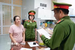 Cơ quan điều tra tống đạt các quyết định đối với Nguyễn Thị Mẫn. (Ảnh: TTXVN phát)