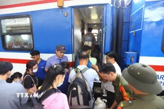 Hành khách xếp hàng lên tàu. (Ảnh: Lê Xuân/TTXVN)