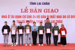 Chủ tịch xã Mường Than, tỉnh Lai Châu, Nguyễn Thị Thu Thủy trao Giấy chứng nhận quyền sử dụng đất và tài sản trên đất cho các hộ dân. (Ảnh: Quý Trung/TTXVN)