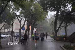 Mưa nhỏ khiến đường ướt và trơn trên đường phố Hà Nội. (Ảnh: Mai Hiền/TTXVN phát)