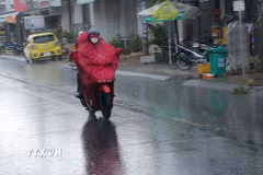 Người dân thành phố Sóc Trăng lưu thông trên đường trong mưa. (Ảnh: Tuấn Phi/TTXVN)