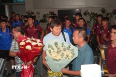 Ban lãnh đạo đội tuyển nhận hoa chúc mừng của các cổ động viên. (Ảnh: Trung Tuyến/TTXVN)
