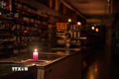 Thắp nến trong cửa hàng ở Barcelona, Tây Ban Nha khi điện bị mất trên diện rộng. (Ảnh: THX/TTXVN)
