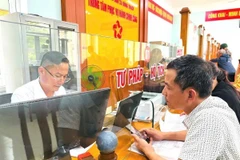 Giải quyết thủ tục hành chính cho người dân tại Trung tâm phục vụ hành chính công xã Đông Trạch, Quảng Trị. (Ảnh: TTXVN phát)