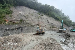 Lực lượng chức năng khẩn trương khắc phục sạt lở tại vị trí Km1405-1408 đường Hồ Chí Minh, đoạn qua đèo Lò Xo. (Ảnh: Cao Nguyên/TTXVN)