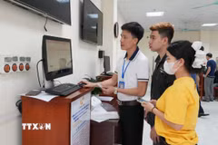 Cán bộ Trung tâm Phục vụ hành chính công phường Vĩnh Yên hướng dẫn người dân làm thủ tục đăng ký kết hôn trên cổng dịch vụ công trực tuyến. (Ảnh: Nguyễn Thảo/TTXVN)