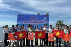 Hải đoàn 32 - Bộ Tư lệnh Vùng Cảnh sát biển 3 tặng quà và cờ Tổ quốc cho ngư dân xã Cà Ná. (Ảnh: TTXVN phát)