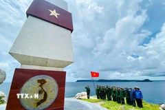Cán bộ, chiến sỹ Đồn Biên phòng Thổ Châu và nhân dân địa phương thăm mốc giới điểm A1 (đường cơ sở Việt Nam đánh dấu dùng để tính chiều rộng lãnh hải trên vùng biển Việt Nam). (Ảnh: Văn Sĩ/TTXVN)