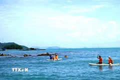 Du khách trải nghiệm chèo sup và lặn mò hải sản ở ven quần đảo Hải Tặc. (Ảnh: Văn Sĩ/TTXVN)